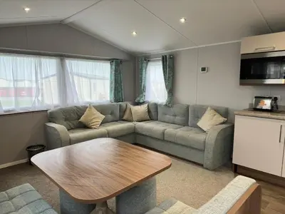 a living room with a couch and a table at Perranporth Beach 3 Bed Holiday Home Cornwall. in Perranporth