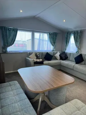 a living room with a table and a couch at Perranporth Beach 3 Bed Holiday Home Cornwall. in Perranporth