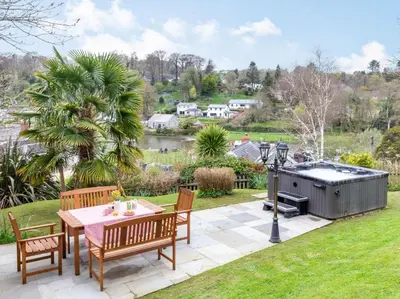 a patio with a table and chairs and a barbecue at 4 Bed in Lostwithiel oc-51028 in Lerryn