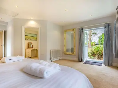 a bedroom with two white beds and a large window at 4 Bed in Lostwithiel oc-51028 in Lerryn
