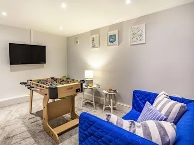 a living room with a blue couch and a chess table at 4 Bed in Lostwithiel oc-51028 in Lerryn