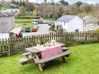 a picnic table in a yard next to a fence at 4 Bed in Lostwithiel oc-51028 in Lerryn