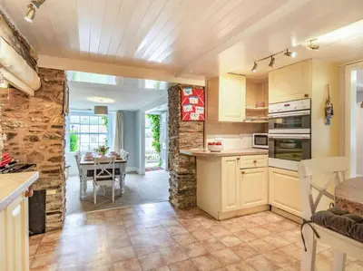 a kitchen with a table and a dining room at 4 Bed in Lostwithiel oc-51028 in Lerryn