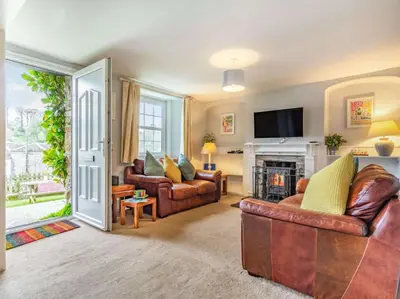 a living room with leather furniture and a fireplace at 4 Bed in Lostwithiel oc-51028 in Lerryn