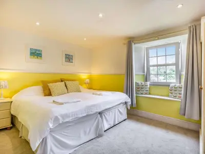 a bedroom with a white bed and a window at 4 Bed in Lostwithiel oc-51028 in Lerryn