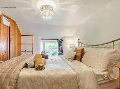 a bedroom with a large bed with a chandelier at 2 Bed in St. Agnes oc-72422 in St. Agnes