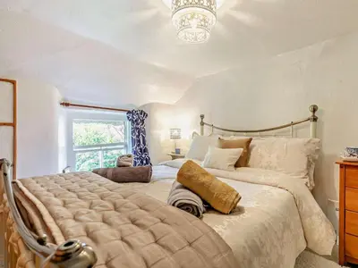 a bedroom with a large bed and a chandelier at 2 Bed in St. Agnes oc-72422 in St. Agnes