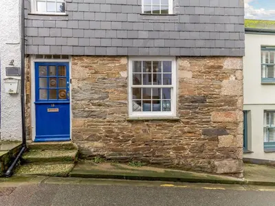 a stone house with a blue door and a window at 2 Bed in Fowey oc-76624 in Fowey