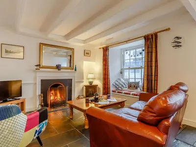 a living room with a couch and a fireplace at 2 Bed in Fowey oc-76624 in Fowey