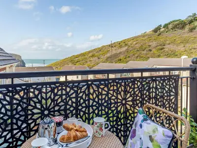 a table with a plate of food on a balcony at 2 Bed in Truro oc-86648 in Porthtowan