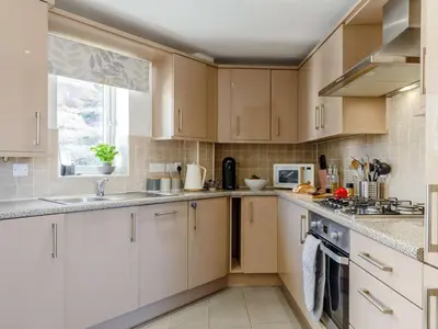 a kitchen with white cabinets and a window at 2 Bed in Truro oc-86648 in Porthtowan