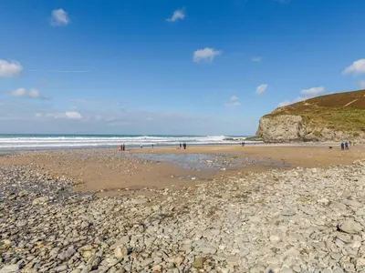 a beach with rocks and people on the beach at 2 Bed in Truro oc-86648 in Porthtowan
