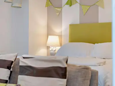 a bedroom with a bed with a green headboard and a lamp at 4 Bed in St. Austell oc-41199 in Charlestown