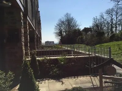 a building with a fence next to a yard at 4 Bed in St. Austell oc-41199 in Charlestown