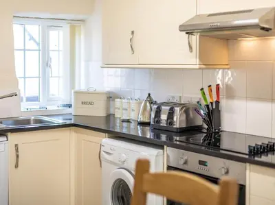 a kitchen with a stove top oven next to a dishwasher at 2 Bed in Helston oc-41378 in Cury