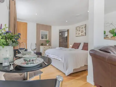 a living room with a bed and a table with a coffee table at 1 Bed in Bude oc-53410 in Saint Gennys