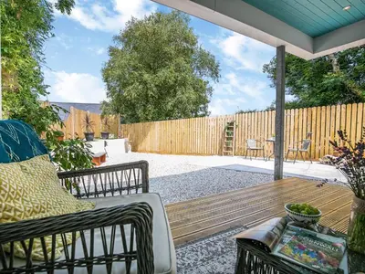 a patio with a bench and a wooden deck at 1 Bed in Bude oc-53410 in Saint Gennys