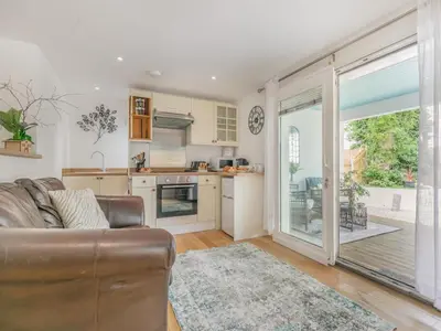 a living room with a couch and a kitchen at 1 Bed in Bude oc-53410 in Saint Gennys