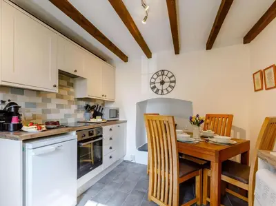 a kitchen with a wooden table and chairs in a room at 2 Bed in Launceston oc-85912 in Trewen