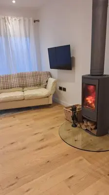 a living room with a wood stove in a living room at Rural Cornish Cottage in Truro