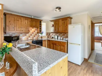 a kitchen with wooden cabinets and a white refrigerator at 1 Bed in Helston oc-bbird in Saint Martin