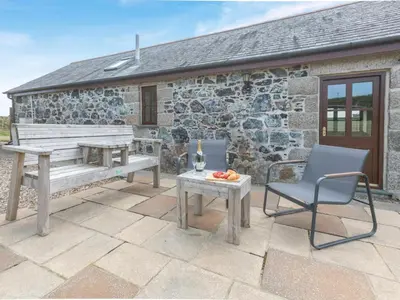 a patio with a bench and a table and a chair at 1 Bed in Helston oc-bbird in Saint Martin