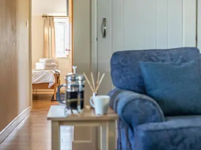 a living room with a blue couch and a table at 1 Bed in Helston oc-41381 in Cury