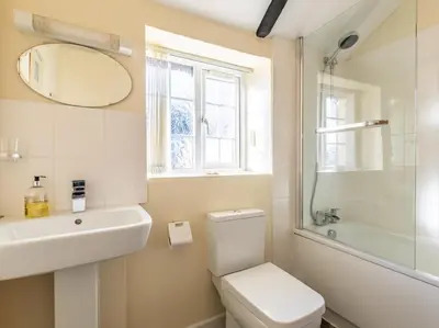 a bathroom with a toilet and a sink and a mirror at 1 Bed in Helston oc-41381 in Cury