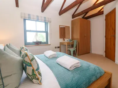 a bedroom with a bed with two pillows on it at 5 The Old Smokehouse in St Austell