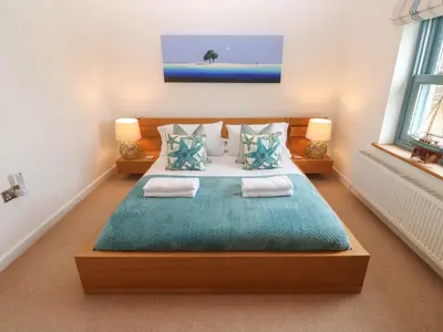 a bedroom with a large bed with two pillows at 5 The Old Smokehouse in St Austell