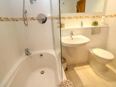 a bathroom with a tub and a toilet and a sink at 5 The Old Smokehouse in St Austell