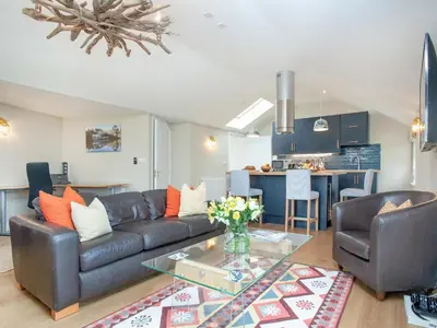 a living room with a couch and a table at Meadowside in Saint Mawes