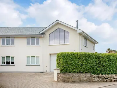 a white house with a hedge at Meadowside in Saint Mawes