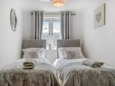 a bedroom with two beds and a window at The Beach Retreat in Porth