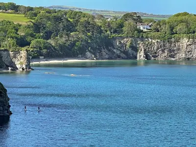 two people are swimming in a large body of water at The Beach Retreat in Porth