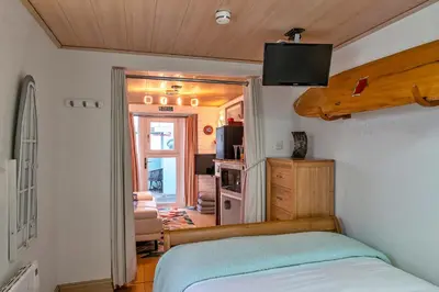 a bedroom with a bed and a tv on the wall at Finest Retreats - Treknow Summerhut in Tintagel