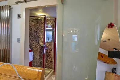 a bathroom with a shower and a glass door at Finest Retreats - Treknow Summerhut in Tintagel
