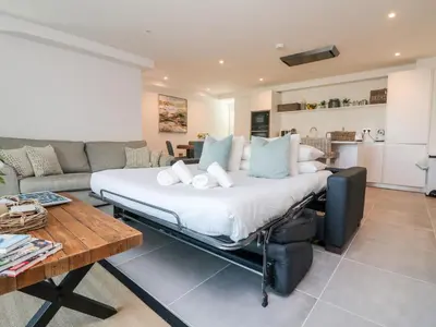 a large bed in a living room next to a couch at 31 Cliff Edge in Newquay