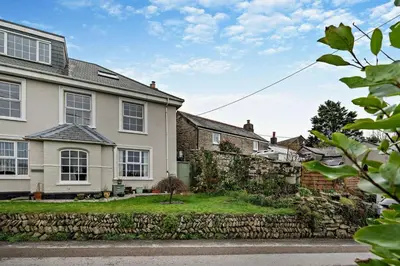 a house with a stone wall and a yard at 3 Bed in St. Breward oc-g28144 in Saint Breward