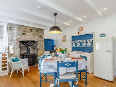 a kitchen with a table and chairs and a fireplace at 2 Bed in Par- oc-81252 in Saint Blazey