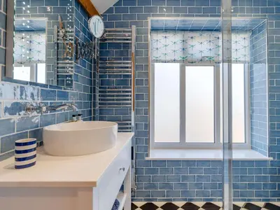 a blue tiled bathroom with a sink and a window at 2 Bed in Holsworthy oc-82455 in Week Saint Mary