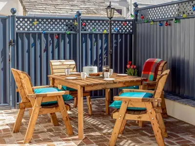 a wooden table and chairs on a patio at 2 Bed in Holsworthy oc-82455 in Week Saint Mary