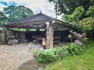 a wooden pergola with a bench in a garden at 2 Bed in Launceston oc-85894 in South Petherwin