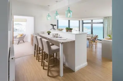 a kitchen with a large island with bar stools at Scots Craig in St Ives