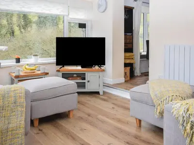 a living room with a flat screen tv and two chairs at 2 Bed in St. Austell oc-88402 in Mevagissey