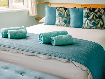 a bed with blue pillows on top of it at 2 Bed in St. Austell oc-88402 in Mevagissey