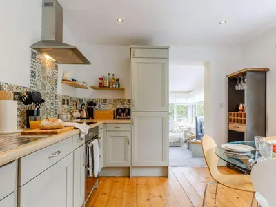 a kitchen with white cabinets and a glass table at 2 Bed in St. Austell oc-88402 in Mevagissey