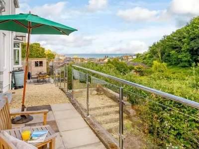 a patio with an umbrella and a view of the ocean at 2 Bed in St. Austell oc-88402 in Mevagissey