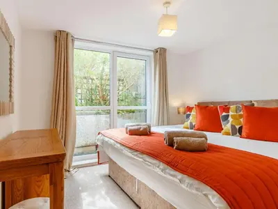 a bedroom with a bed with an orange blanket and a window at 2 Bed in St. Austell oc-88402 in Mevagissey