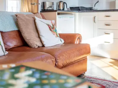 a brown leather couch with a white pillow on it at 1 Bed in Helston oc-41377 in Cury